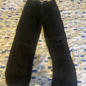 Svarta jeans från Bershka - Säljer ett par svarta high waist jeans från Bershka. De har en straight passform och slitna detaljer på knäna. Säljs pga rensning 💕