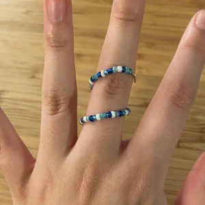 Blå ring, pärlor, justerbar - Egentillverkad ring av pärlor och ståltråd💙Justerbar storlek och form. Om man drar ut ringen helt är den ca 11cm. Det går att beställa i valfri färg/färger💅🏼