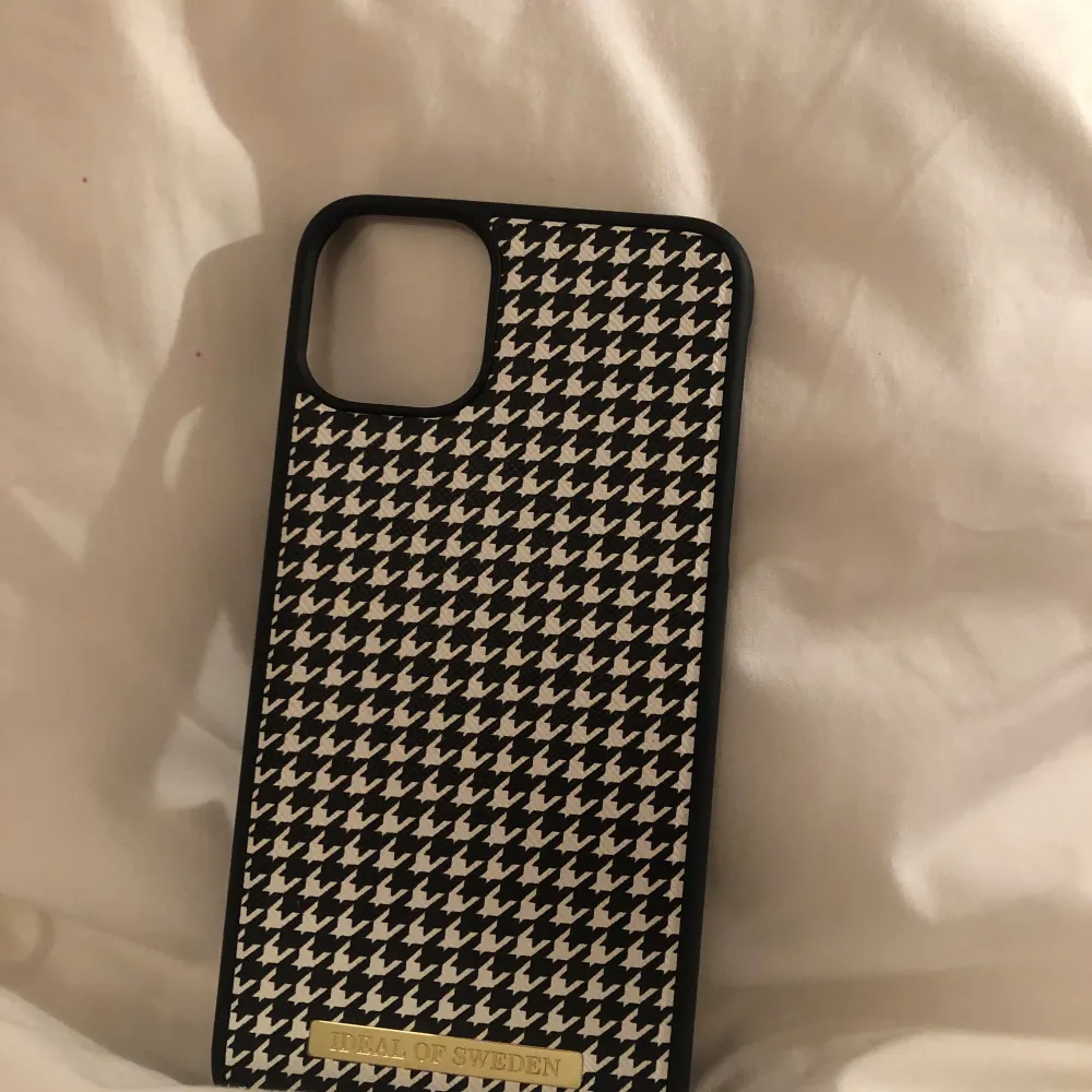 Snyggt mobilskal från Ideal of Sweden i svart och vitt med ett klassiskt hundtandsmönster. Skalet har en stilren design och är perfekt för att ge din mobil en trendig look. Passar utmärkt för att skydda din telefon med stil.. Muu.