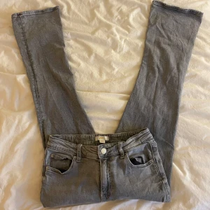 Grå bootcut jeans  - Gråa bootcut jeans, midrise/lowrise ish, bra skick dock är de liite slitningar längst ner på benen men inget som märks
