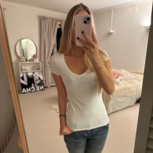 Vit kortärmad topp - Säljer en enkel och stilren vit kortärmad topp med rund halsringning. Perfekt basplagg för alla tillfällen. Passar bra till jeans eller kjol.