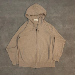 Beige cashmere hoodie - Säljer en lyxig beige kashmir hoodie. Tröjan har dragkedja framtill och en bekväm huva. Perfekt för kyliga dagar när du vill ha något stilrent och bekvämt.