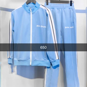 Träningsset från Palm Angels - Snyggt träningsset från Palm Angels med dragkedja och vita ränder längs ärmarna. Finns i flera färger: ljusblå, svart, vit och grön. Perfekt för en sportig look.
