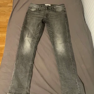 Gråa jeans  - Snygga gråa jeans från Stock&Hank med en klassisk straight fit. De är perfekta för en avslappnad stil. Byxorna har dragkedja. Storleken är W30 L30.