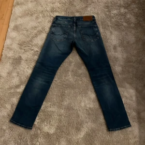 Blåa jeans från Jack n Jones slim/straight - Snygga blå jeansbyxor med en klassisk slim passform. De har en diskret tvättad look och fyrficksdesign. Perfekta för en avslappnad stil.