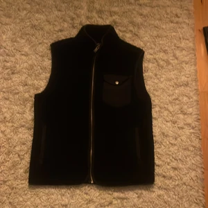 Svart fleeceväst från Bandeid - Riktigt Snygg svart fleeceväst passar perfekt nu när vi börjar välkomna varmare dagar. Passar till många outfits och är populär. Säljs pga för liten på mig. Skriv vid minsta funderingar!💯
