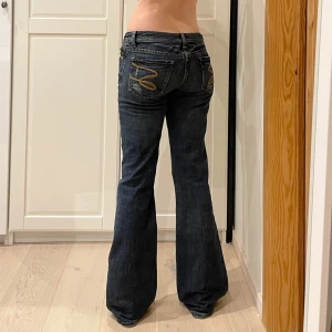 Lågmidjade bootcut jeans med snygga detaljer🤩 - Midja 40 cm rakt över, gren 19 cm o innerben 83 cm💕Jae 169 o xs-s för referens o de passar men är mer åt S än xs