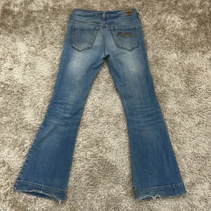 Blå jeans med bootcut från Replay - Snygga ljusblå low waist jeans från Replay med bootcut-stil. Säljer för att de är för små för mig. Passar om du är ca 145-155cm. Välanvända, skick enligt foton. 🩷