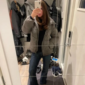 Grå pufferjacka från Massimo Dutti - Säljer en snygg grå pufferjacka från Massimo Dutti. Jackan har en dragkedja framtill och en hög krage för extra värme. Perfekt för kyliga dagar och ger en stilren look.