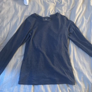 Mörkblå långärmad tröja från hm - Säljer en stilren mörkblå långärmad tröja från HM. Tröjan har en enkel design och är gjord i ett mjukt material.