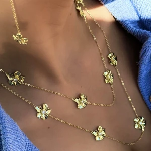 Guldhalsband med blommotiv - Elegant guldhalsband med flera blommotiv längs kedjan. Perfekt för att ge en touch av lyx och stil till din outfit. Halsbandet har en fin glans och är lätt att matcha med andra smycken. Från Ioaku säljes då de tyvärr inte kommer till användning💕