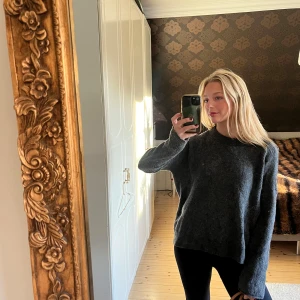 Mörkgrå stickad tröja - Säljer en mysig mörkgrå stickad tröja med lång ärm. Perfekt för kyliga dagar och ger en avslappnad look. Passar bra till jeans eller leggings. Tröjan har knappar på ryggen💞