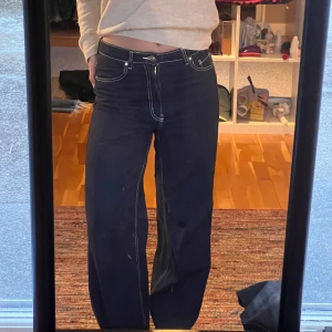 Mörkblå jeans från H&M - Snygga mörkblå jeans från H&M med vita sömmar. Byxorna har en hög midja och en straight passform. Kommer inte till användning längre.