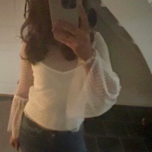 Vit blus från Gina Tricot - Säljer en söt vit blus från Gina Tricot🤍 i storlek XS. Blusen har långa, transparenta ärmar med prickigt mönster och en lätt volangdetalj vid ärmsluten. Perfekt för en stilren och elegant look.🤍🎉🪩