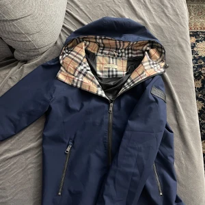Burberry Windbreaker - Hej, som du ser så säljer jag nu min välanvända windbreaker. Har fått lite gummilimm vid ärmen. Går säkert bort om man vet hur man kan ta bort det! Annars inget annat.  Storlek M-passar mer som S.