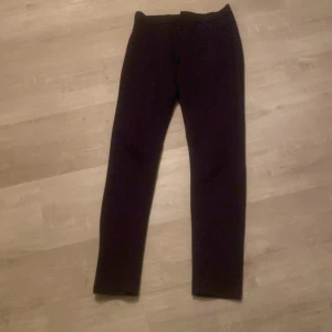 Svarta byxor - Snygga svarta byxor med en tight passform. Perfekta för en stilren look. De har en enkel design utan synliga detaljer och är gjorda i ett mjukt material.