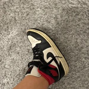 Nike Air Jordans i svart, vitt och rött - Säljer ett par klassiska Nike Air Jordans i svart, vitt och rött. Skorna har snörning och den ikoniska Air Jordan-loggan. Perfekta för sneakerheads som vill ha en tidlös stil.