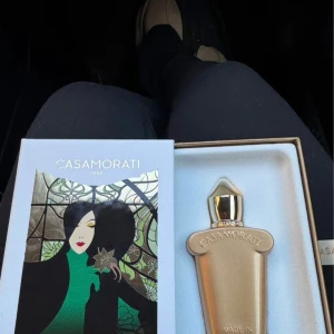 Casamorati Lira Eau de Parfum - Xerjoff casamorati LIRA endast testad med 1 sprut.  30 ml.  Original pris är 1300 kr.  Mystisk och provocerande, Lira Casamorati gör ett slående uttalande som är svårt att motstå. Toppnoter av färsk bergamott och blodapelsin leder näsan till ett klassiskt hjärta av ros, jasmin och lakritsblomma. I Lira av Casamorati ger gourmandbasnoterna av vanilj, mysk och karamell ett sus i förförelsen. En inspirerande vintagedoft som hyllar den antika italienska parfymkonsten.