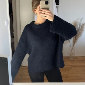 Mörkblå stickad tröja - Säljer en mysig mörkblå stickad tröja med en avslappnad passform. Tröjan har långa ärmar och en rund halsringning. 
