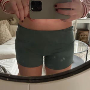 Gröna högmidjade shorts - Snygga gröna högmidjade shorts perfekta för träning eller en avslappnad dag. De har en tight passform och är gjorda i ett stretchigt material som ger bra rörelsefrihet. Perfekta för träningens alla aktiviteter!