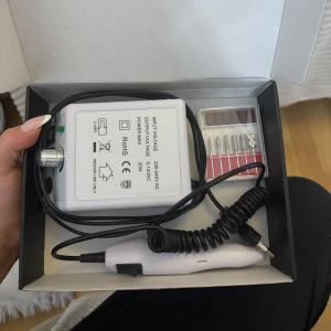 Elektrisk nagelfil med tillbehör - Säljer en elektrisk nagelfil med flera olika sliphuvuden. Enheten har justerbar hastighet och är enkel att använda med en strömbrytare på handtaget. Perfekt för manikyr, naglar och pedikyr. Fungerar precis som den ska. Säljer då jag fått en ny som är mindre bara. 💕