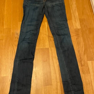 Blå jeans från Replay - Snygga blå jeans från Replay med klassisk femficksdesign och subtila slitningar. De har en bootcut-stil och är perfekta för en avslappnad look. Märkesdetaljer syns på bakfickan och insidan av linningen. Säljer pga att de inte passar. Sista bilden är inte min men jag har den för att visa hur de sitter på.