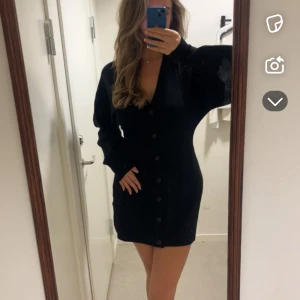 Svart klänning med knappar - Snygg svart klänning med knappar framtill och långärmad.  Jätte skön men tyvärr inte funnit någon användning..