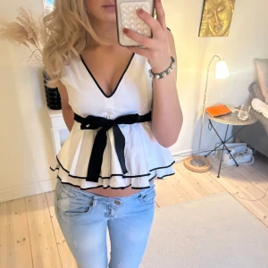 Vit top med svart rosett - Sååå fin topp med en rosett och volanger!❤️‍🔥😍