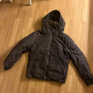 Colmar Jacka - Säljer en snygg svart vinterjacka  från Colmar. Den har en dragkedja framtill och en klassisk bomberstil med ribbade muddar. Perfekt för vintern. Väldigt varm, säljer den för att den inte passade mig. Jag är 191 och väger 91 kg. 
