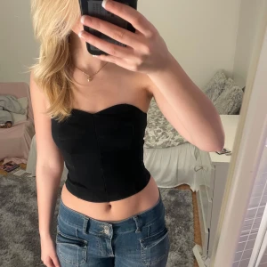 Svart tubtopp från Aware - Säljer en stilren svart tubtopp från Aware i storlek XS. Toppen har en elegant och enkel design med en smickrande passform. Perfekt för en utekväll eller fest! 🖤