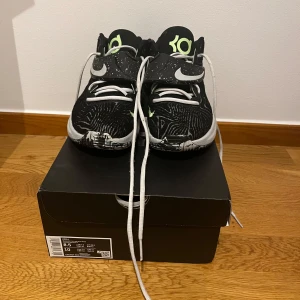 Svarta Kevin Durant 14 basketskor  - Snygga Kevin Durant sneakers i svart med vita och limegröna detaljer. Skorna har ett unikt mönster och snörning för en säker passform. Perfekta för basket eller vardagsbruk. Storlek 42 kan träffas inom Stockholm, Ny pris 1975kr