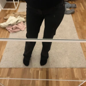 Svarta jeans - Snygga svarta jeans med en klassisk design. De har en rak passform och är perfekta för en stilren look. Byxorna har en knapp och dragkedja framtill.