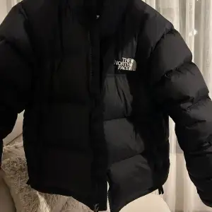 Säljer en snygg och varm svart dunjacka från The North Face i storlek L. Jackan har en pufferstil med dragkedja och är perfekt för kalla vinterdagar. Den är i mycket bra skick och redo för nya äventyr! 🖤