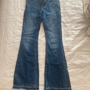 Blå bootcut jeans - Säljer ett par snygga blå bootcut jeans i bra skick. De har en klassisk femficksdesign och är perfekta för både vardag och fest. Jeansen har en skön passform och är tillverkade i slitstarkt denim. Perfekta för höst och vår! De är även uppssprättade längst ner vilket är en så fin detalj. De är i banrstorlek men jag skulle säga att dem passar någon som har xs och som är cirka 160 lång. Tveka inte att höra av dig vid frågor eller fler bilder! 