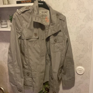 Grå/grön jacka från Esprit - Säljer en snygg grå/grön jacka från Esprit i mycket bra skick. Jackan har långa ärmar och flera fickor med knappar framtill. Bra skick, säljer för 200!🌸 storlek M/40 
