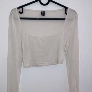 Beige långärmad croppad topp från H&M - Säljer en stilren beige långärmad topp från shein i storlek XS. Den är croppad och perfekt för både vardag och fest. Toppen är i ett mjukt och bekvämt material som passar bra till jeans eller kjol. Ett måste i garderoben! 💫