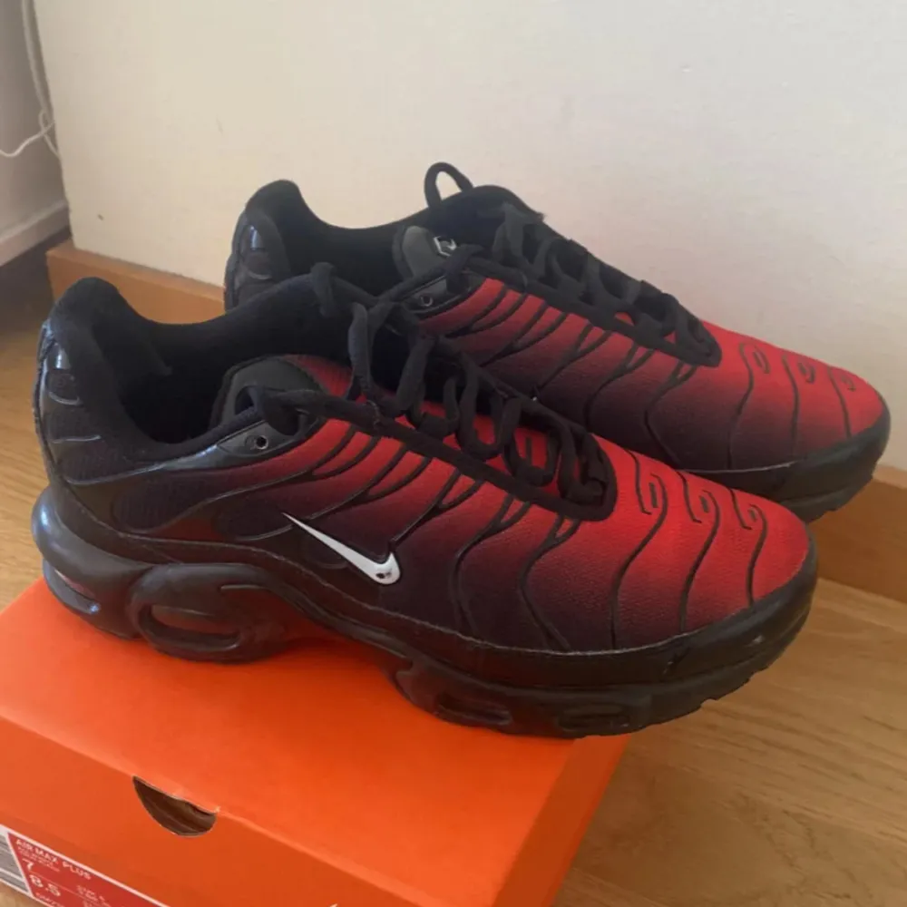 Säljer ett par Nike Air Max Plus i en cool röd och svart färgkombination. Skorna har en snygg vågig design och är i mycket bra skick. Perfekta för både vardag och träning. De har en bekväm passform och klassisk snörning. Kommer i originalkartong.. Skor.