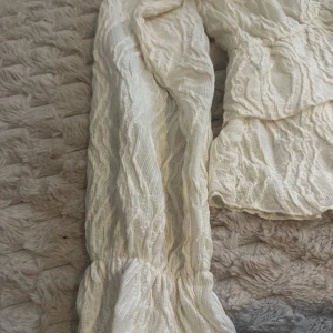 Vit blus från Gina Tricot - Säljer en superfin vit blus från Gina Tricot i storlek XL. Den har en v-ringad design och är tillverkad i ett lätt och luftigt material med en skrynklig textur. Perfekt för både vardag och fest! Helt ny med prislapp kvar.