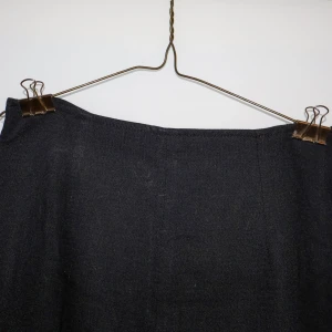 Svart långkjol - Säljer en elegant svart långkjol i bra skick. Kjolen har en stilren design med en diskret slits framtill som ger en snygg detalj. Perfekt för både vardag och festliga tillfällen. Passar utmärkt till höst- och vintergarderoben.