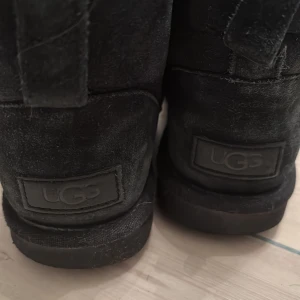 Svarta UGG skor ❣️ - Säljer ett par svarta UGG i storlek 36. Den ena  har haft ett litet hål men som är lagat som man kan se. Nu ser det mer bara ut som snö eller smuts❣️