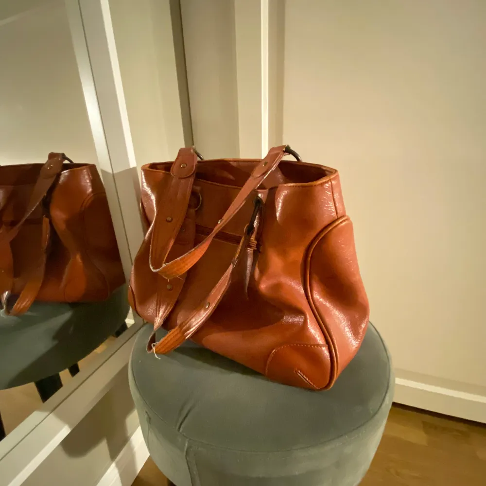 Säljer en snygg brun skinnväska i mycket bra skick. Den har en klassisk design med två rejäla handtag och stilrena detaljer. Perfekt för både vardag och jobb, med gott om plats för alla dina saker. Väskan är både praktisk och stilfull, en riktig garderobsklassiker!. Laukut & Käsilaukut.