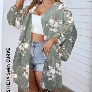Blommig kimono från SHEIN - Snygg och luftig kimono från SHEIN i grönt med vackert blommönster. Perfekt för sommardagar eller som en lätt jacka över en topp. Den har vida ärmar och en lös passform som ger en avslappnad look.