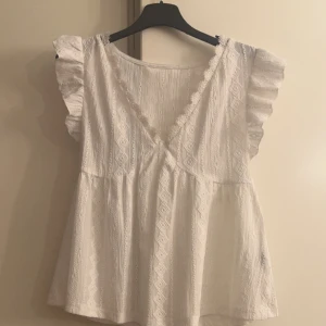 Vit blus med volangärmar - Säljer en söt vit blus med volangärmar och v-ringning. Storlek xs men passar s oxå fint skick 