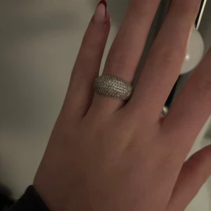 Glittrig ring i silver - Säljer en superfin glittrig ring i silver. Den har en bred design och är täckt med små gnistrande stenar. Ringer är från safira och använd en gång.