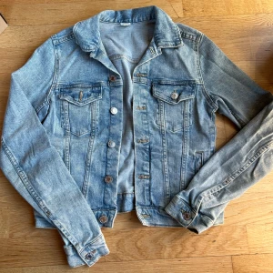 Ljusblå jeansjacka från h&m - Säljer en snygg ljusblå jeansjacka från &Denim i storlek 34. Jackan har en klassisk design med knappar framtill och två bröstfickor. Bra skick! Bara en lite fläck som syns på sista bilden 💙