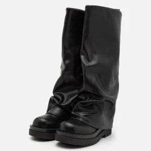 Svarta stövlar i faux skinn - Säljer ett par svarta stövlar i skinn med en cool, slouchy design. De har en robust sula och är perfekta för höst och vinter. Stövlarna är i mycket bra skick och passar perfekt för en edgy look. Perfekta för att hålla stilen i kallare väder! Använda 1 gång.