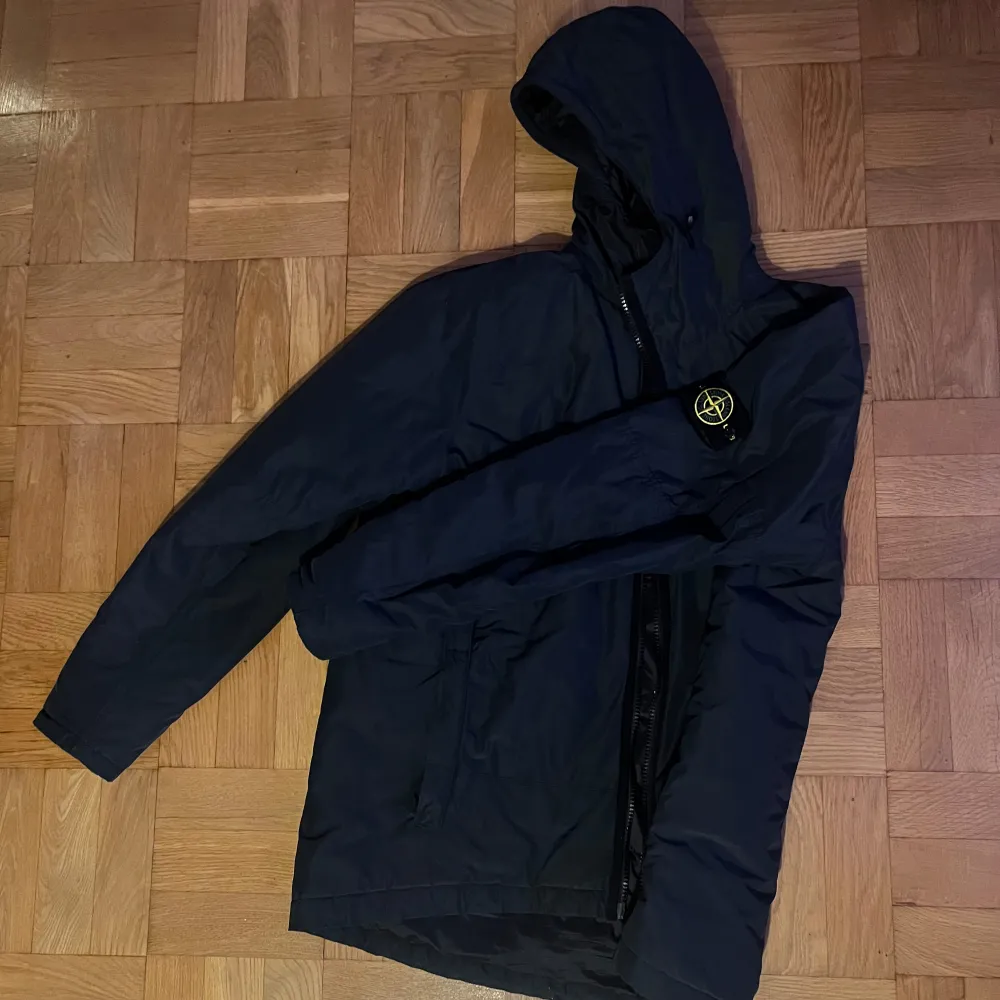 Säljer en svart vinterjacka från Stone Island. Mycket bra skick och varm. Jackan har en praktisk luva och dragkedja framtill. Perfekt för kalla vinterdagar, och den är långärmad. Storlek: XL-L Nypris: 9250kr. Jackor.