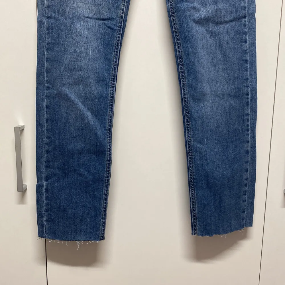 Säljer ett par klassiska blå jeans från i mycket bra skick. De har en skinny passform och är perfekta för både vardag och fest. Jeansen har en knapp och dragkedja framtill samt fem fickor. Obs: Jag har kortat av dem lite eftersom de var för långa för mig.. Jeans & Byxor.