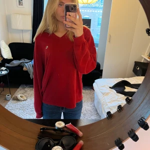 Röd vintage tröja från Lacoste - Säljer en vintage  röd tröja från Lacoste. Den har en v-ringning och  krokodilmärket på bröstet. Tror det är herrmodell men jag har använt den som en oversized tröja