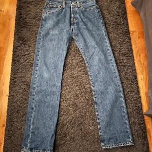 Levi's 501 Jeans - Säljer ett par klassiska Levi's 501 jeans i blå denim. De har en rak passform och är i mycket bra skick. Perfekta för både vardag och fest! 🕺